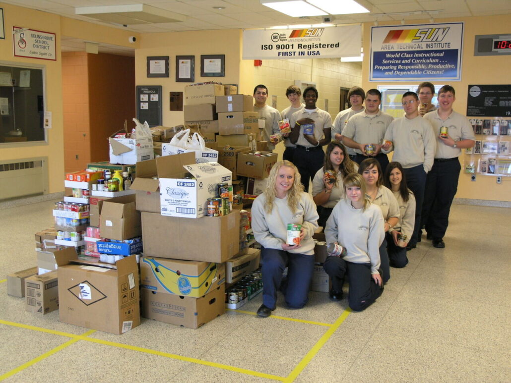 Criminal Justice poses with the mountain of food donated during the fall 2012 food drive.