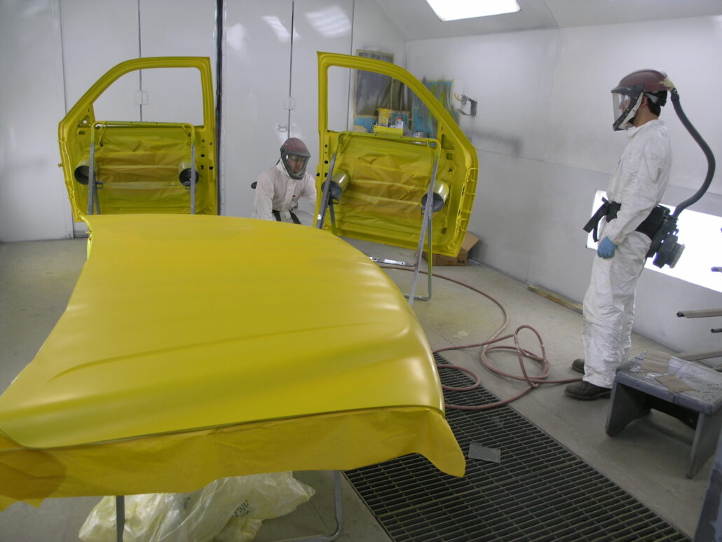 Tyler Spear and Steve Rank painting the doors for a truck being refinished for the City of Sunbury.