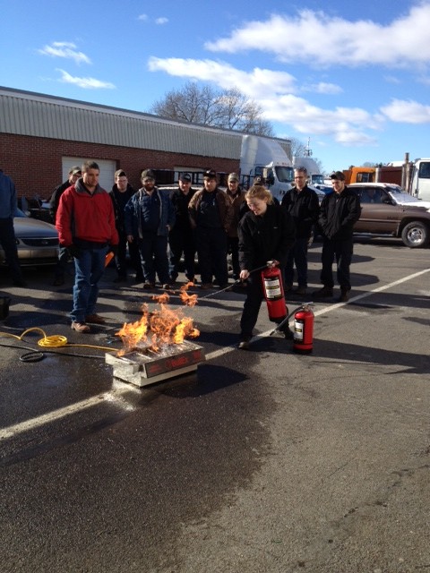Grace Juliano of Auto Tech Trains with a Fire Extinguisher