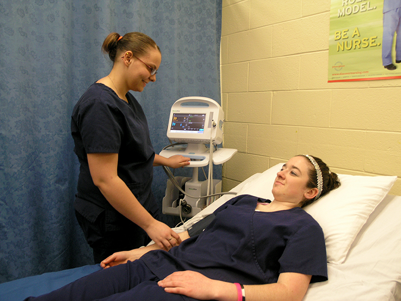 Justice checks Jessica's blood pressure using a state-of-the-art device used in hospitals and doctor's offices.